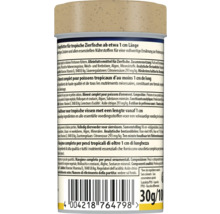 Zadní strana krmiva pro tropické ryby od délky přibližně 1 centimetr, se složením, nutričními hodnotami, čárovým kódem a hmotností 30 gramů.