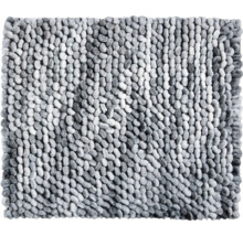 Detailní záběr na strukturovanou koupelnovou předložku s měkkým povrchem připomínajícím oblázky.