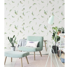 Světlý obývací pokoj s botanickou tapetou s motivem listů, čalouněným křeslem s podnožkou a různými pokojovými rostlinami.