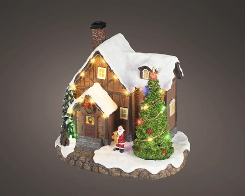 Miniaturní vánoční domeček ze dřeva se zasněženou střechou, osvětleným stromkem a malou figurkou Santa Clause.