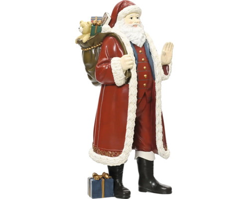 Figurka Santa Clause s pytlem plným dárků na zádech a dárkovým balíčkem u nohou, tradiční vánoční dekorace.
