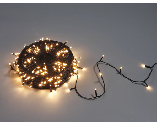 LED světelný řetěz na černé plastové cívce s teple bílými světly pro vánoční dekoraci.