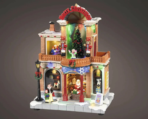 Osvětlený vánoční obchod s hračkami s figurkami, vánočním stromkem, louskáčky a nápisem Merry Christmas pro vánoční vesničky.