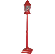 Červená vánoční pouliční lampa s efektem sněhové koule, figurkou Santa Clause a vánočním stromkem.