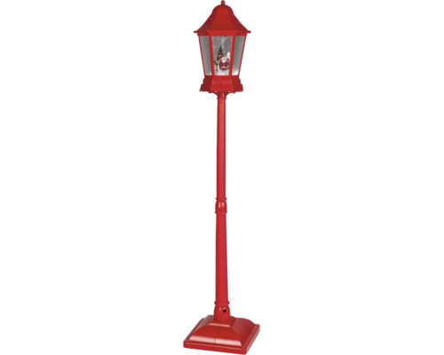 Červená vánoční pouliční lampa s efektem sněhové koule, figurkou Santa Clause a vánočním stromkem.