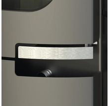 Detailní záběr na moderní rukojeť krbových kamen z kartáčovaného kovu v prohlubni.