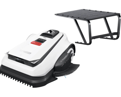 Bílá robotická sekačka s černou garáží jako přístřeškem.