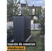 Moderní kovový zahradní domek v tmavě šedé barvě na trávníku v zahradě před domem.