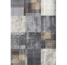 Koberec s patchworkovým vzorem, různými geometrickými a ornamentálními motivy a vintage vzhledem.