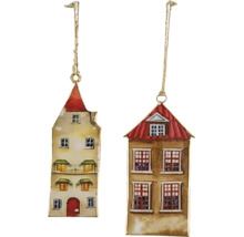 Dvě vánoční ozdoby ve tvaru historických městských domů, vyrobené z kovu s malovanými detaily a šňůrkou na zavěšení.