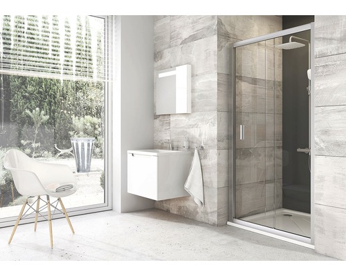 Světlá koupelna se sprchou, umyvadlovou skříňkou a židlí