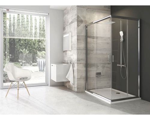 Moderní koupelna se sprchovým koutem, umyvadlem a židlí ve světlém pokoji.