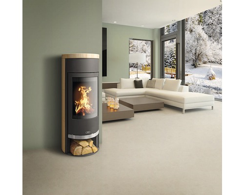 Obývací pokoj s kamny, pohovkou a výhledem na zasněženou krajinu