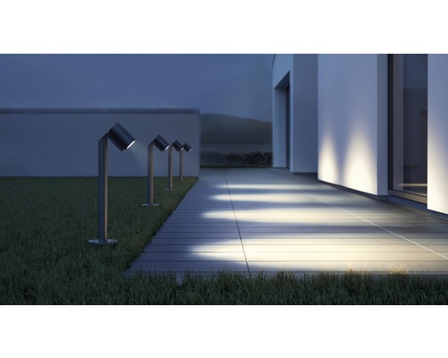 Řada zahradních svítidel vedle cesty na trávníku