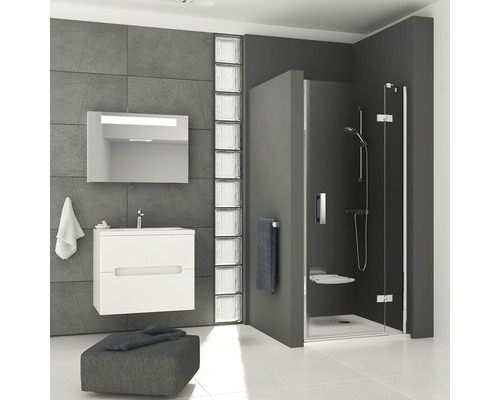 Moderní koupelna s umyvadlem, zrcadlem, skleněnými tvárnicemi a sprchovým koutem.