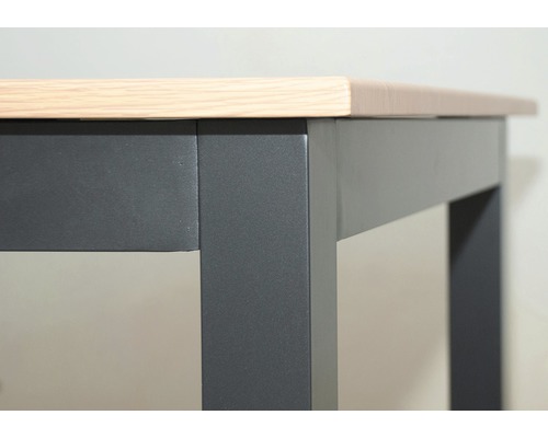 Detailní pohled na stůl se světlou dřevěnou deskou a tmavým rámem