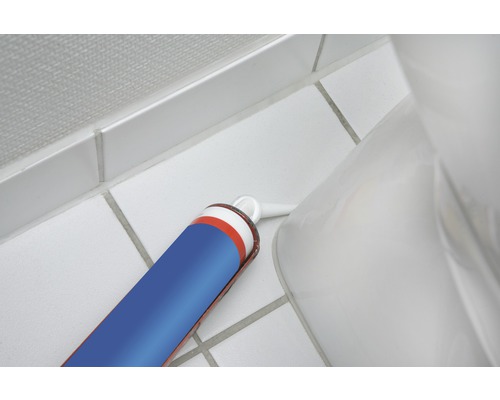 Sanitární silikonová kartuše tmelu vedle toalety na koupelnových dlaždicích