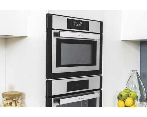 Vestavěná mikrovlnná trouba a trouba značky Candy v moderní kuchyni.