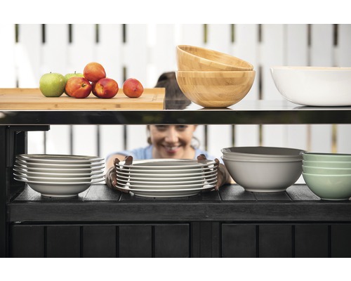 Police s nádobím, včetně stohů talířů a misek z různých materiálů