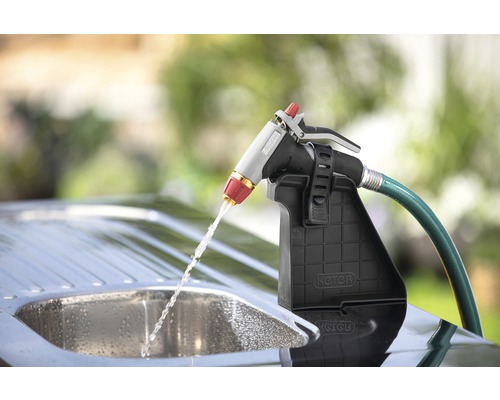 Zahradní hadicová sprcha s držákem a proudem vody nad dřezem