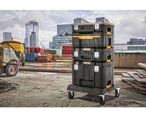 Naskládané kufříky na nářadí značky DeWalt na rolovací desce na pozadí města.