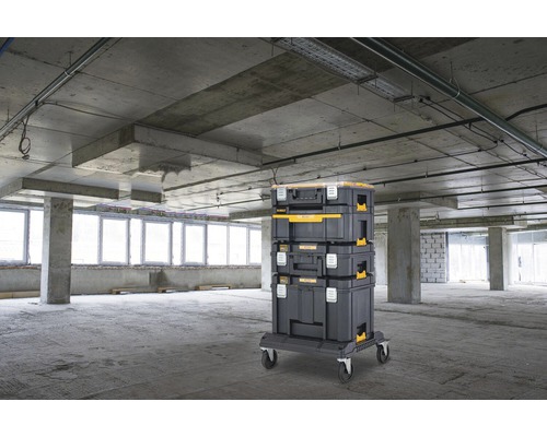 Stohovatelné kufry na nářadí na kolečkové desce v hrubé stavbě