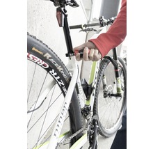 Detailní záběr na kolo, jehož sedlovka je nastavována nástrojem.