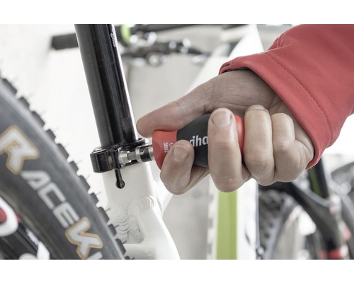 Muž používá šroubovák Wiha na kole.