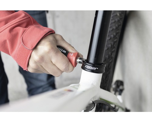 Osoba používá nářadí na kole k opravě.