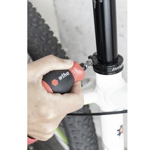 Osoba upevňuje sedlovku jízdního kola šroubovákem Wiha.