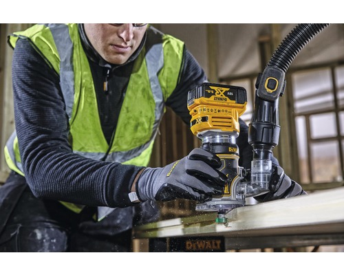 Řemeslník pracující s horní frézkou DeWalt na kusu dřeva.