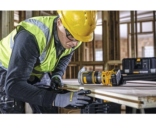 Řemeslník pracuje s horní frézkou DeWalt na dřevěné desce