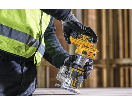 Osoba připevňuje baterii k horní frézce Dewalt