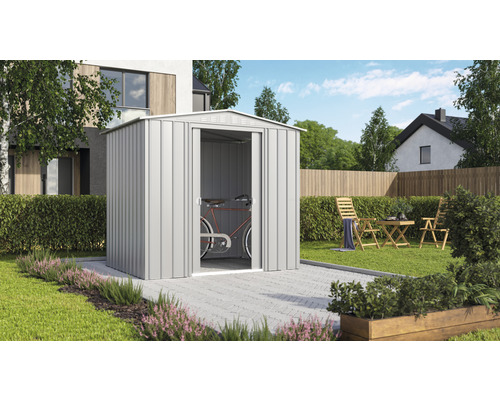 Zahradní scéna s kovovým zahradním domkem a jízdním kolem uvnitř.