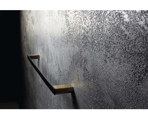 Stěna se strukturovanou omítkou a kovovým madlem