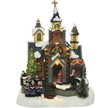 Osvětlený vánoční kostel s postavami sboru jako dekorace