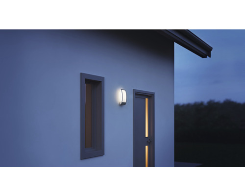 Venkovní nástěnné svítidlo vedle okna a dveří na stěně domu