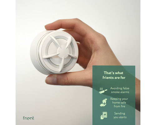 Ruka drží bílý hlásič kouře značky Frient