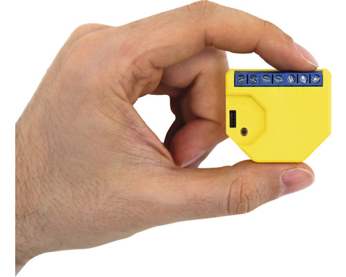 Žlutý chytrý domácí spínač v ruce