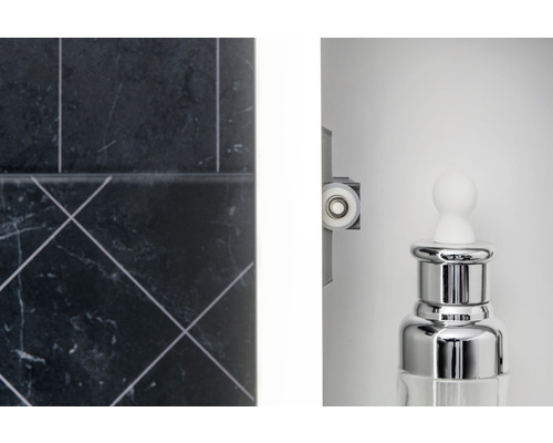 Detailní záběr koupelny s obklady, rolnou sprchového koutu a dávkovačem