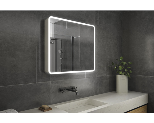 Koupelna s osvětlenou zrcadlovou skříňkou, umyvadlem a vodovodní baterií.