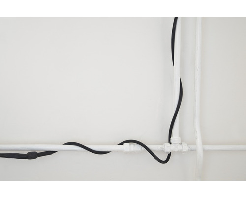 Instalace s plastovými trubkami a elektrickým kabelem na zdi