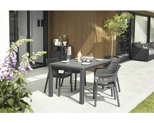 Zahradní scéna s jídelním stolem a židlemi na terase.