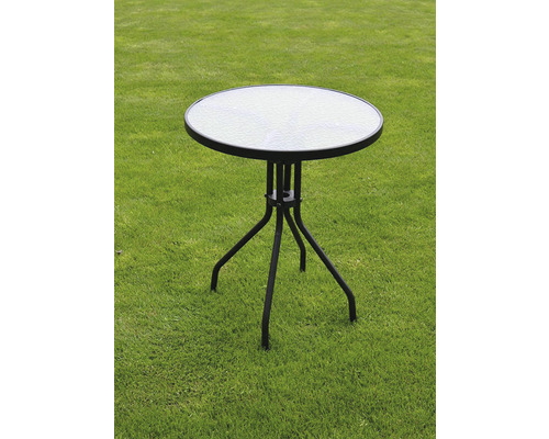 Zahradní stůl se skleněnou deskou a kovovým rámem na trávníku