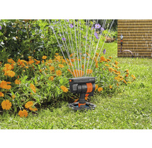 Zahradní scéna se zavlažovačem trávníku v akci pro zavlažování květin