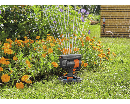 Zahradní scéna se zavlažovačem trávníku v akci pro zavlažování květin