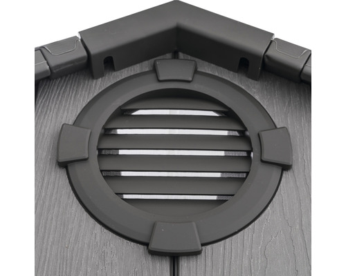 Detail zahradního domku s kulatým oknem a větracími mřížkami