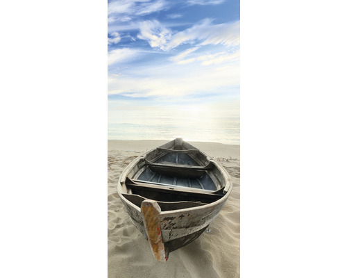 Malý člun leží na písečné pláži.