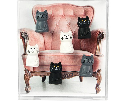 Dekorace s kočičími figurkami před křeslem