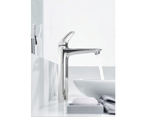 Umyvadlová baterie s tekoucí vodou ve světlé koupelně.